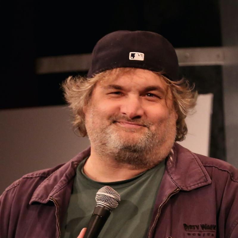 Comedian Artie Lange smirks for the camera while holding a microphone