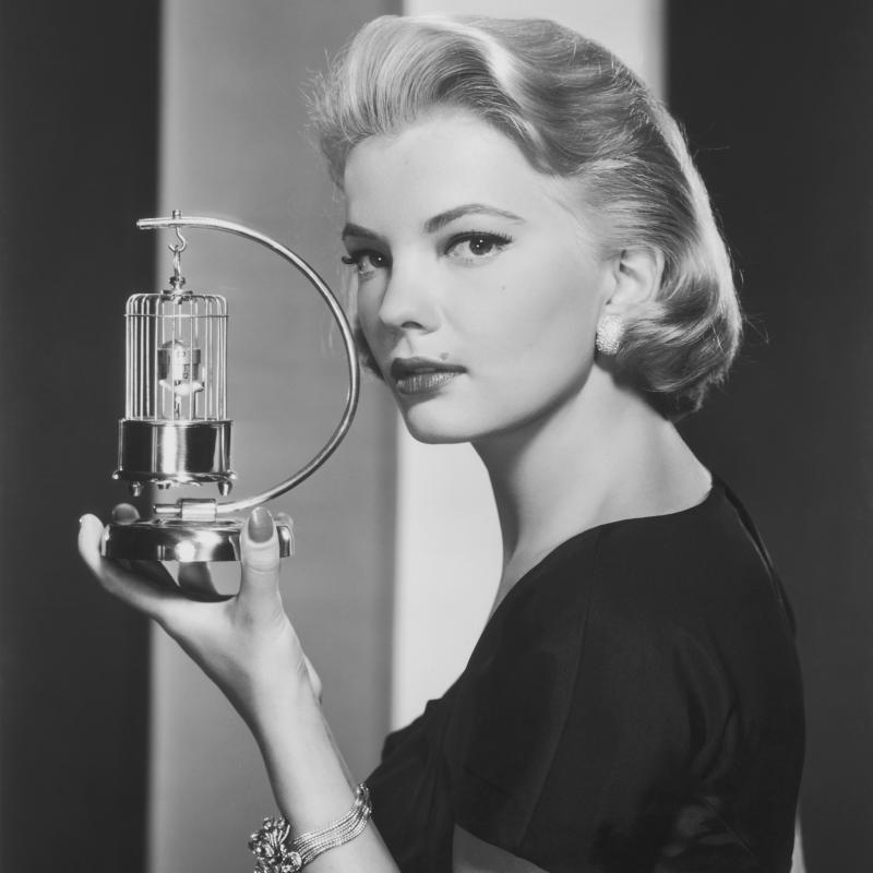 Actress Gena Rowlands pictured holding an ornament depicting a bird in a cage, USA, circa 1958.
